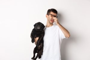 man disgusted by dog's bad breath
